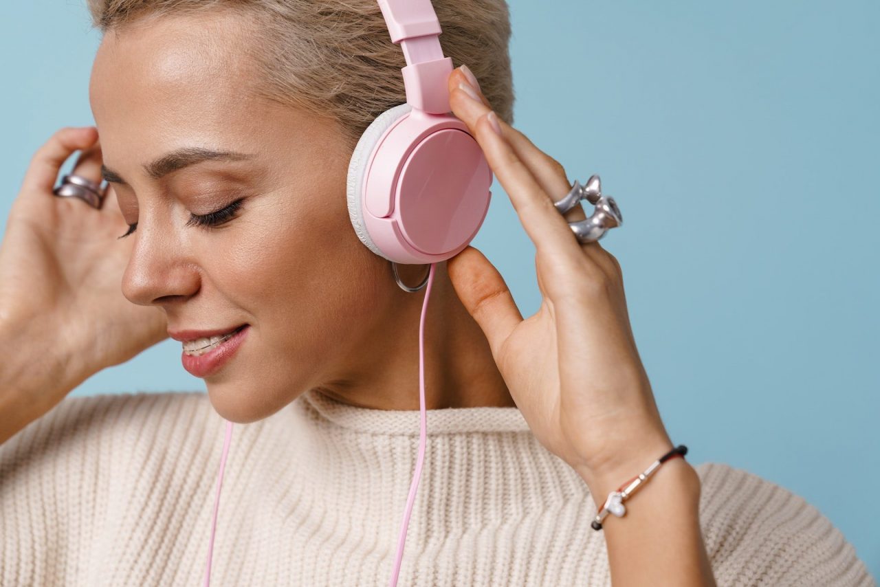 Cheerful beautiful girl listening music with headphones